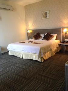 Bagan SeraiK Garden Hotel (BS)的酒店客房配有一张带白色床单和枕头的大床。