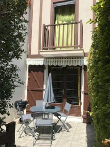 库尔瑟勒·苏尔·梅尔Maisonnette du bonheur的庭院配有桌椅和遮阳伞。