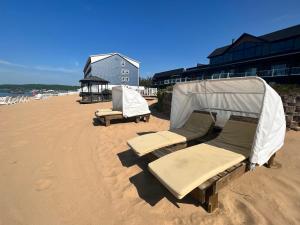特拉弗斯城海滩酒店 - 特拉弗斯城的海滩上摆放着几把椅子和帐篷