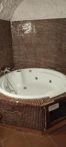 瓜迪克斯拉塔拉卡萨斯石窟旅馆的带浴缸的浴室和棕色瓷砖墙