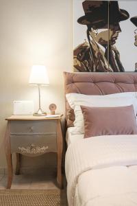 科莫蒂尼Remvi的一间卧室配有一张床和一个带台灯的边桌