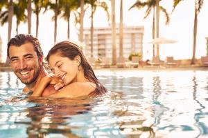 迈阿密迈阿密四季酒店的男女在游泳池游泳