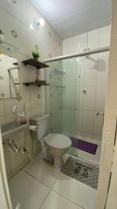 马拉戈日Manancial Flats的一间带卫生间和玻璃淋浴间的浴室