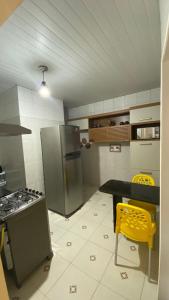 马拉戈日Manancial Flats的厨房配有冰箱、桌子和黄色椅子