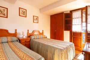 Quintana de LlanesCasa Enrique en el oriente de Asturias的一间卧室设有两张床和窗户。