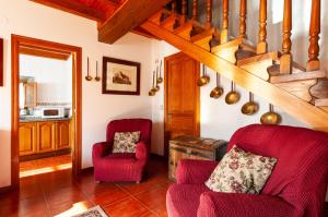 Quintana de LlanesCasa Enrique en el oriente de Asturias的客厅设有2把红色椅子和楼梯