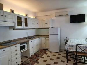 伊斯基亚Villa Martina的厨房配有白色橱柜和白色冰箱。