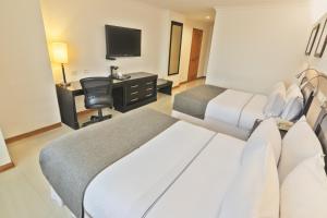 卡利Sonesta Hotel Cali的酒店客房配有两张床和一张书桌