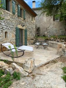 圣昂托南La Pause noble val的石头建筑前方带桌椅的庭院