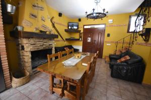 阿尔玛格鲁Casa rural de estilo rustico con SPA的客厅配有桌子和壁炉