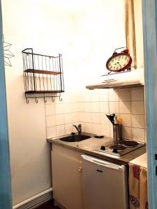 萨尔拉拉卡内达Studio Domaine des Oliviers的厨房配有水槽和墙上的时钟