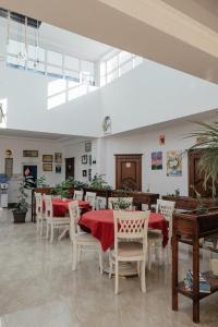 撒马尔罕Casa de Higos的餐厅配有桌椅和红色桌布