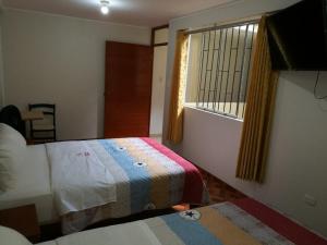 纳斯卡El Sol de Nazca的酒店客房设有两张床和窗户。