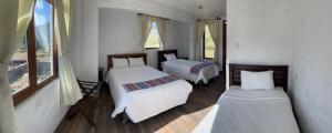 卡瓦纳科德La Casa de Santiago Hotel的一间卧室设有两张床和两个窗户。