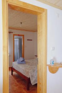 戈伊什Casinha da Eira的一间卧室配有一张木架床