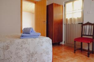 戈伊什Casinha da Eira的卧室配有床、椅子和窗户。