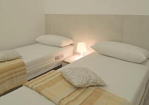 蒙特西尔瓦诺Elegante appartamento a due passi dal mare的带灯的客房内的两张单人床