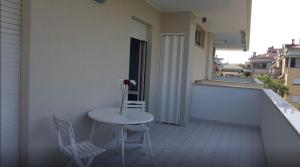 蒙特西尔瓦诺Elegante appartamento a due passi dal mare的阳台上的小白色桌子和椅子