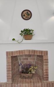 卡拉恩波特Villa Coral的砖砌的壁炉,种植了盆子,钟