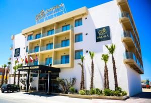 达赫拉Dakhla Boarding Hotel & Restaurant的前面有棕榈树的酒店