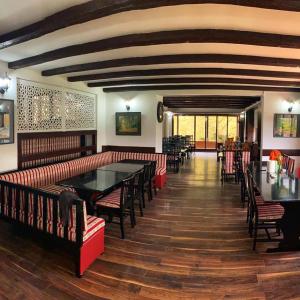 萨拉热窝Teuta Palace Dom Faletići的一间餐厅,房间内设有红色椅子和桌子