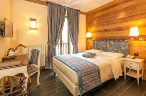 库马约尔索阿特罗酒店的酒店客房配有一张床、一张书桌和一张书桌。
