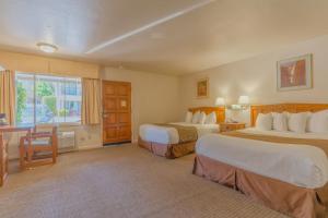 马里波萨Mariposa Lodge的酒店客房设有两张床和窗户。