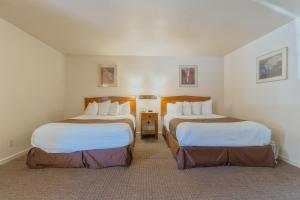 马里波萨Mariposa Lodge的一间酒店客房,房间内设有两张床