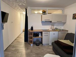 奥米沙利Apartmenthaus Suskovic Insel Krk的一间厨房,内设白色橱柜和沙发
