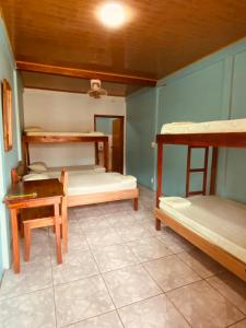 别霍港Cabinas Popular的客房设有三张双层床和一张桌子。