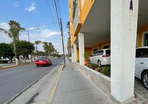 多洛雷斯-伊达尔戈ABERDEEN HOTEL DOLORES HIDALGO的停在大楼旁的街道上的红色汽车