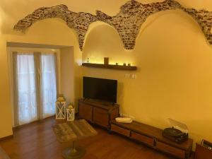 热那亚Il Nido Del Borgo的一间起居室,在黄色的墙上配有平面电视。