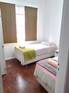 里约热内卢Lindo quarto na Praia de Botafogo的一间卧室设有两张床和窗户。