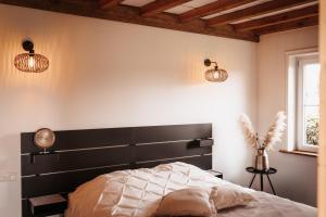 托伦-NIEUW- Luxe & sfeervol Vakantiehuis Tholen的一间卧室配有黑色床头板和2盏灯