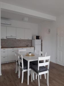 戈斯皮奇Elegant Inn Gospić的白色的厨房配有白色的桌子和椅子