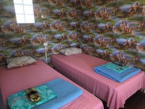 文茨皮尔斯Kempings Vīnkalni的壁画客房内的两张粉红色床铺