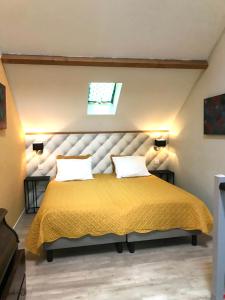 AubazinesMaisonnette la Grue - Vallée de la Dordogne的一间卧室配有一张带两个枕头的大型黄色床