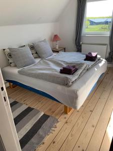 斯凯拜克Jægergård的卧室内的一张大床,铺有木地板