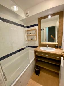 莱索尔Appartement 2 chambres vue pistes, parking privatif的带浴缸、水槽和镜子的浴室