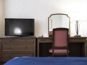 神户神户阿里斯顿酒店的一间卧室配有一张桌子、一台电视和一把椅子