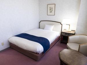 神户神户阿里斯顿酒店的配有一张床和一把椅子的酒店客房