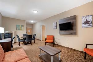 欧文贝斯特韦斯特普拉斯DFW机场套房酒店的客厅配有桌椅和平面电视。