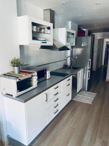 马拉加Fantastic Apartment City Center - Optional Parking的厨房配有白色橱柜和不锈钢用具