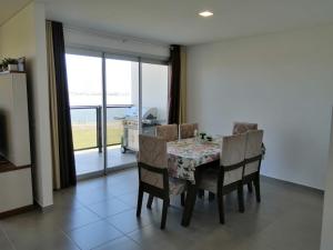 恩卡纳西翁Parana Playa 1103的一间带桌椅和窗户的用餐室