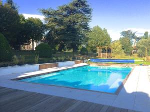 CordelleDomaine des Grands Cèdres的一个带木甲板的庭院内的游泳池