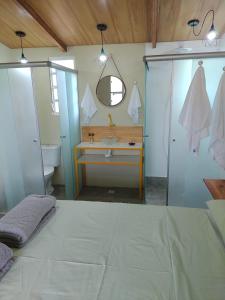 戈亚斯州上帕莱索Flores do Cerrado的浴室设有床、水槽和镜子