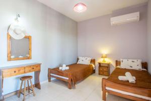 Ágios NikólaosPine tree Apartment & sunset的一间卧室配有两张床、一张桌子和一面镜子