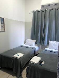 里奥韦尔迪Ágape Hotel的医院的两张床,带毛巾