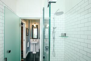 纳皮尔玛索尼克装饰艺术酒店的一间带玻璃淋浴间和水槽的浴室