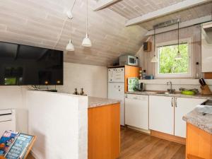 森讷维4 person holiday home in Ringk bing的厨房配有白色橱柜和台面